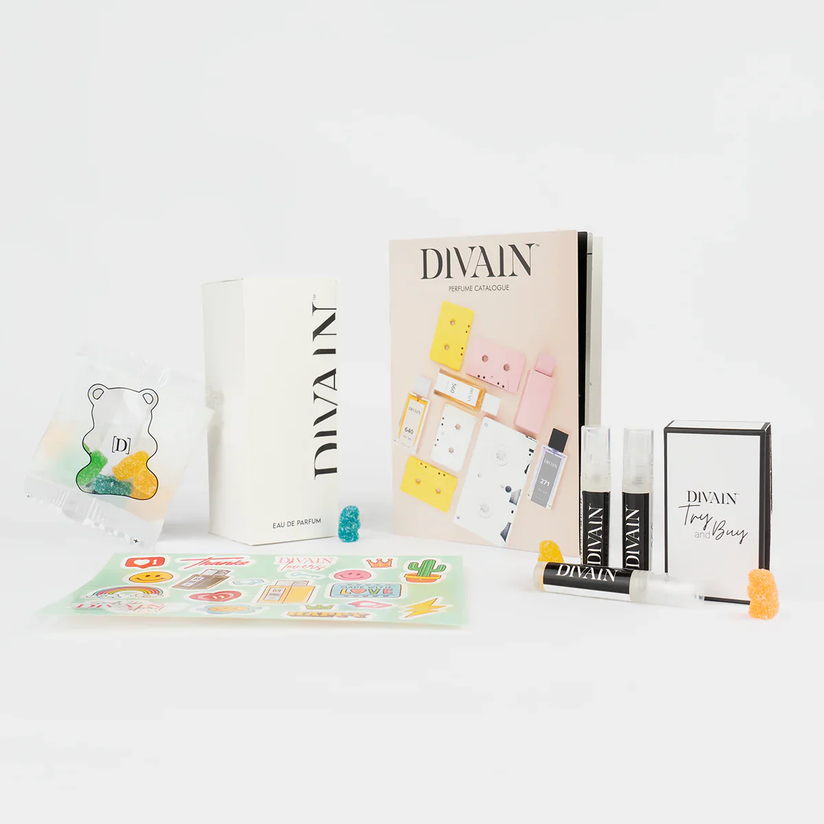 Paquete de divain abierto que contiene el perfume divain-057 , pegatinas y gominolas
