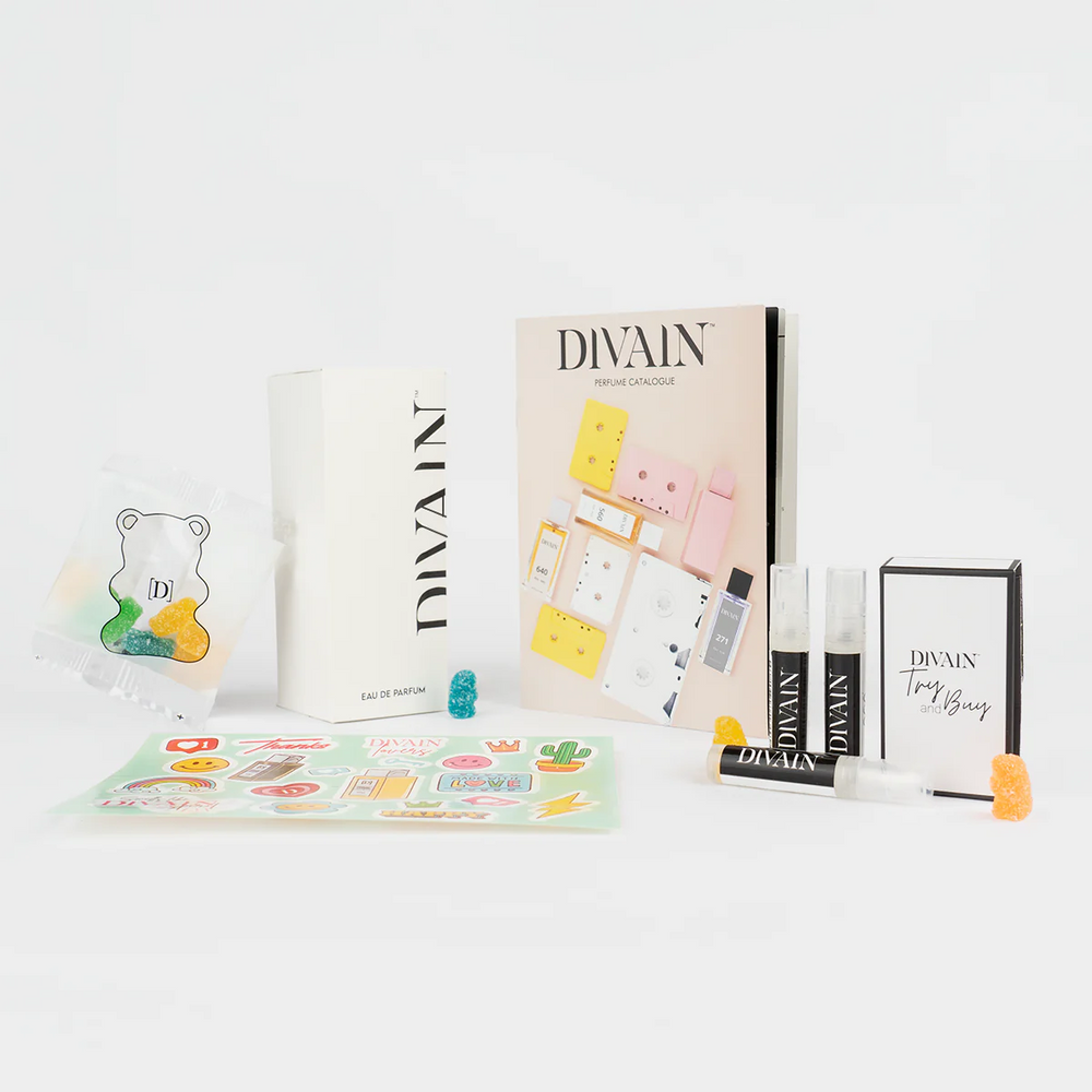 Paquete de divain abierto que contiene el perfume divain-986, pegatinas y gominolas
