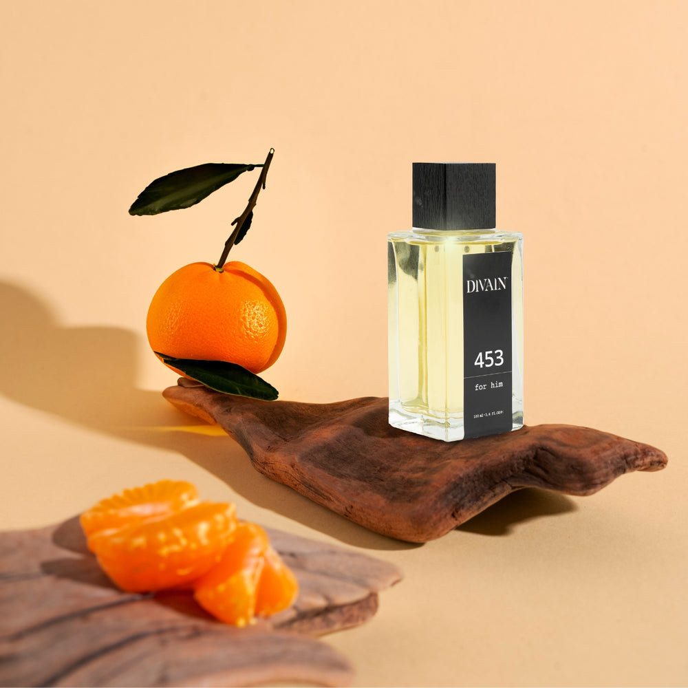 Perfume divain-453 rodeado de sus notas olfativas como la naranja