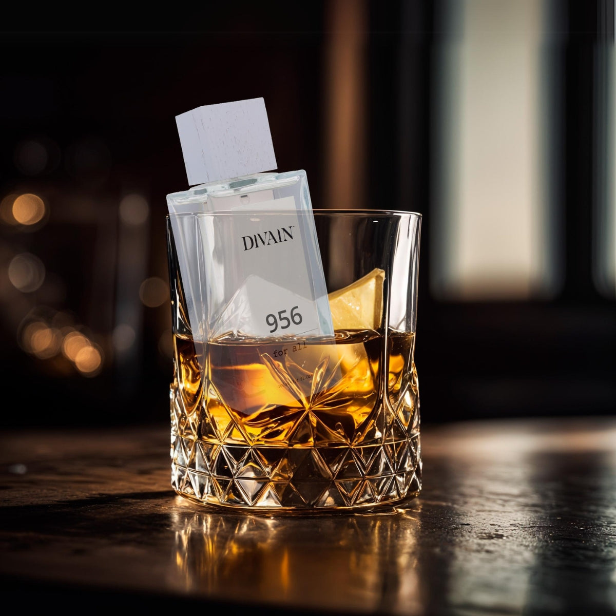 Perfume divain-956 sumergido en un vaso con un liquido que se asemeja al whisky.