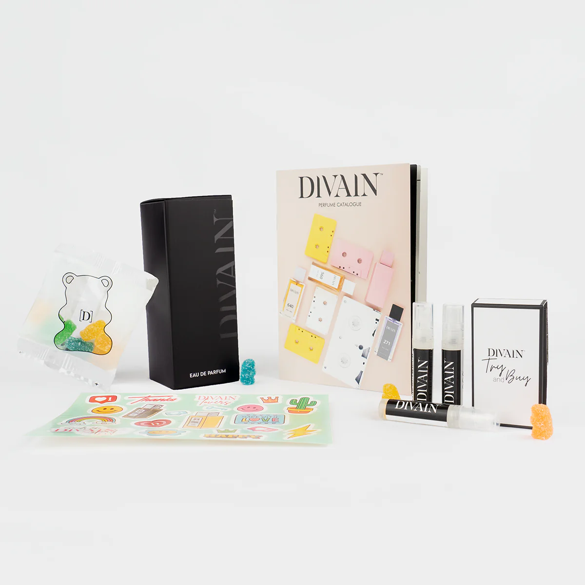 Paquete de divain abierto que contiene el perfume divain-853 , pegatinas y gominolas